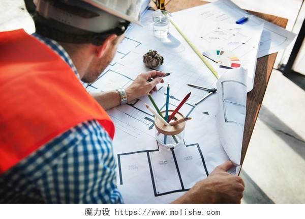 劳动节建筑师带着安全帽在画图纸背景图片